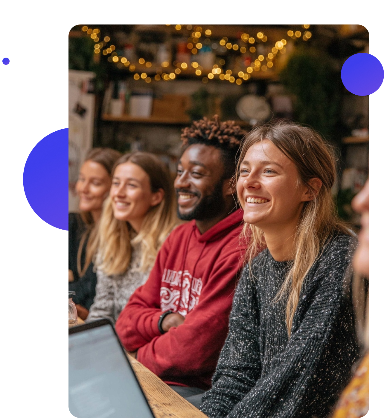 A group of charity workers meeting in a community café, sharing ideas and smiling together around a table.