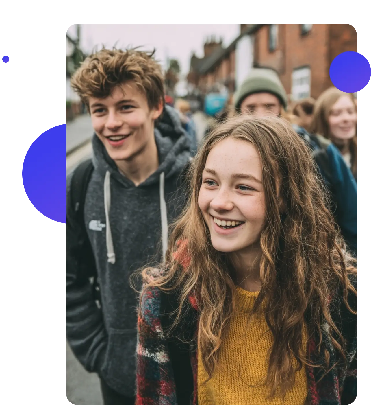 A group of young people walking together along a street, laughing.
